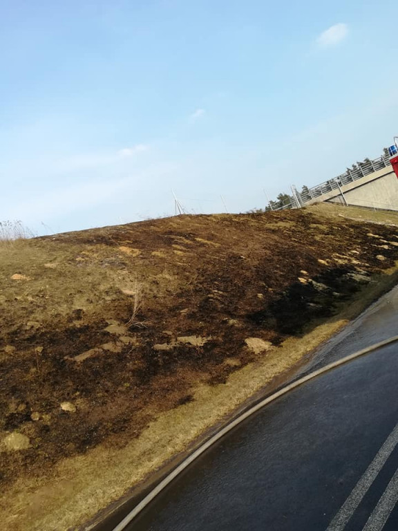 Płonące trawy na nasypie autostrady